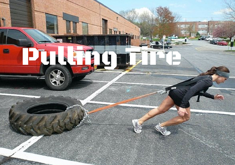 woman pulling a tire in parking lot